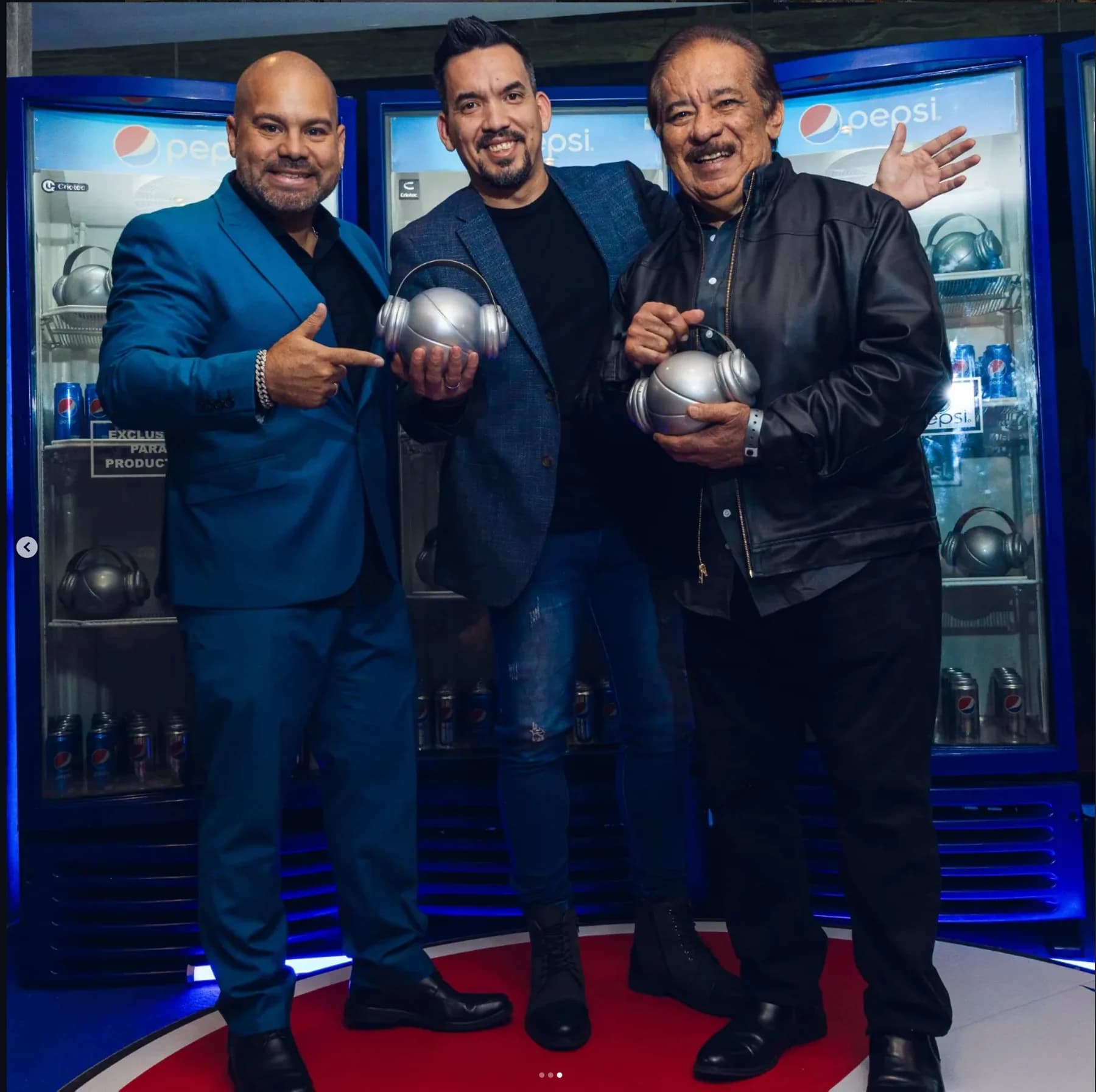 Betulio Medina junto a representantes del evento mostrando reconocimientos de los Premios Pepsi Music 2023.